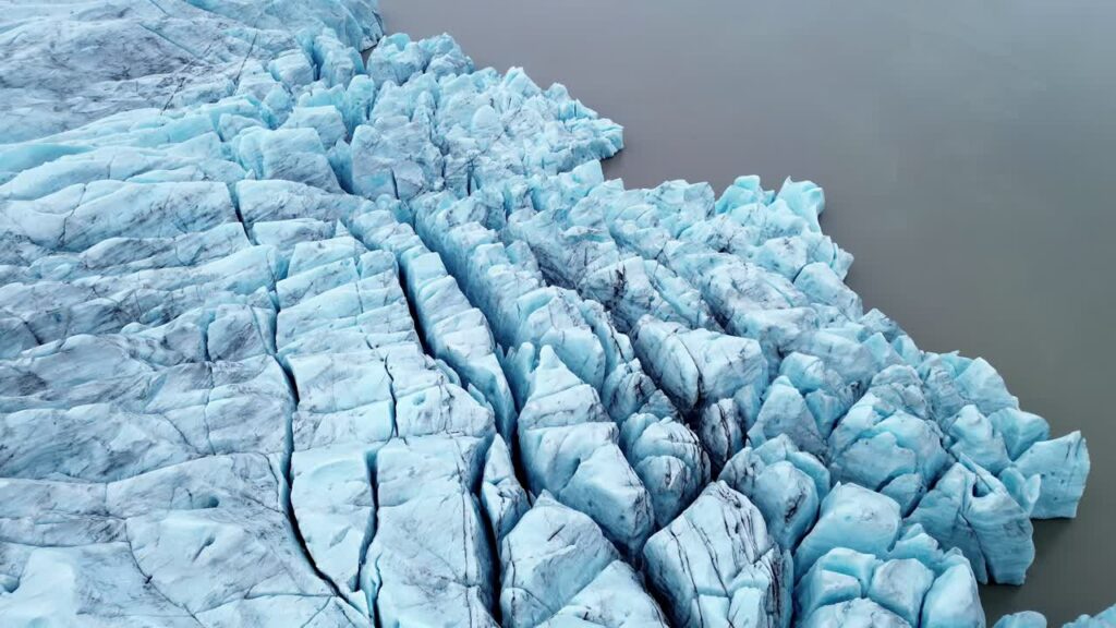 Video – Aerial drone view of Breioamerkurjokull glacier ice formations near Jokulsarlon Lagoon, Iceland. Sharp blue ice blocks and deep cracks form abstract frozen patterns in the glacial landscape - Starpik Stock