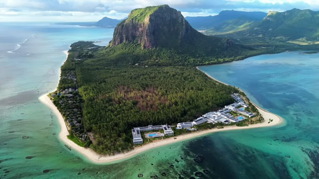 Video – Aerial drone view of Le Morne Brabant peninsula in Mauritius, showing coral reefs, turquoise lagoon waters, and the iconic mountain rising above the tropical coastline - Starpik Stock
