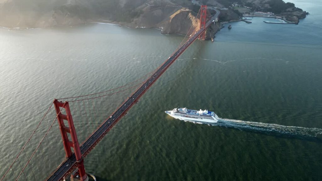 Video – Aerial drone view of a passenger boat passing under the Golden Gate Bridge in San Francisco Bay - Starpik Stock