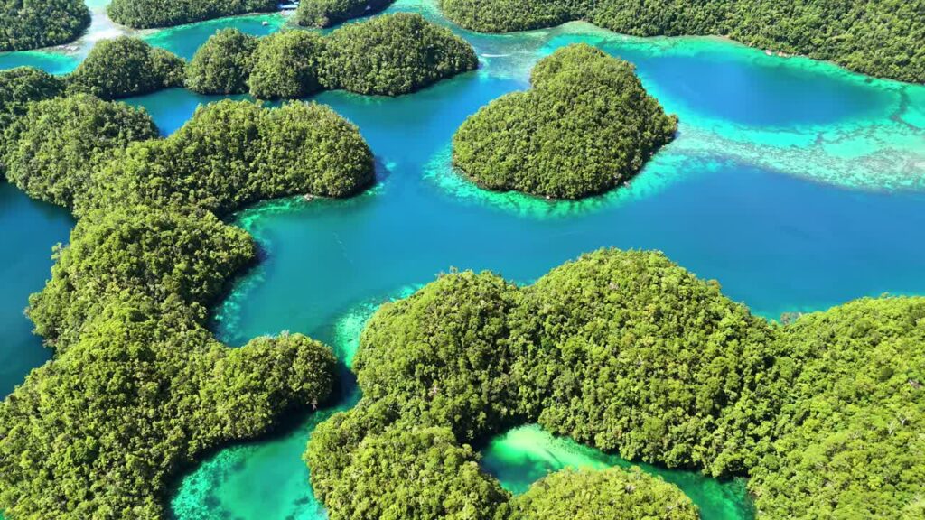 Video – Aerial drone view of the limestone islets and emerald lagoons of Coron Island, Palawan, Philippines. Dense tropical vegetation covers rounded karst formations surrounded by bright turquoise waters and coral reefs - Starpik Stock