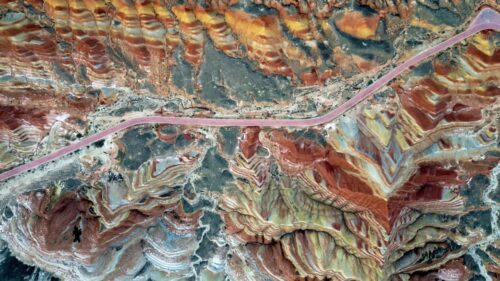 Video - Aerial drone view of vividly layered sedimentary rock formations at Zhangye Danxia Landform Geological Park in Gansu Province, China
