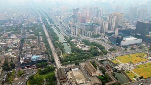 Video - Aerial drone view of central Xi'an, Shaanxi Province, China, featuring a long canal lined boulevard cutting through dense urban residential buildings