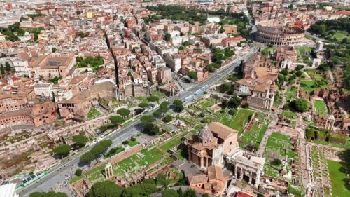 Video - Aerial drone view of the Colosseum and Roman Forum in Rome, Italy. Historic amphitheater and archaeological complex surrounded by classical ruins and greenery