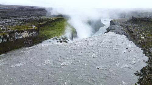 Video - Aerial drone view of Selfoss waterfall upstream from Dettifoss. The wide horseshoe shaped cascade flows over layered basalt cliffs into a rugged canyon landscape carved by ancient glacial floods