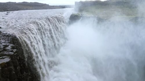 Video - Aerial drone view of Dettifoss waterfall in Vatnajokull National Park, Northeast Iceland. Europe's most powerful waterfall crashes into a mist filled canyon with roaring white water and dramatic volcanic rock cliffs