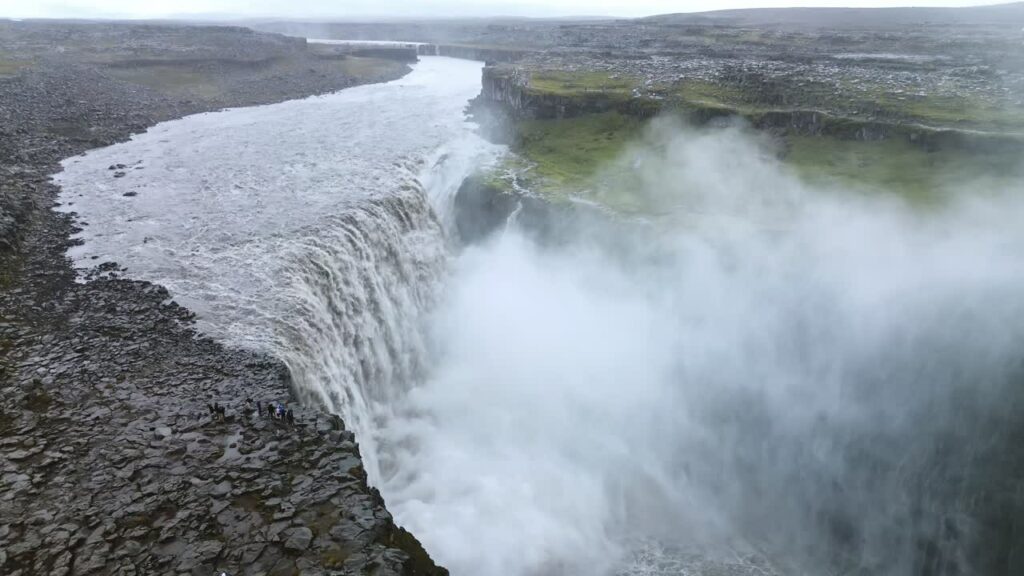 Video - Aerial drone view of Dettifoss waterfall in Vatnajokull National Park, Northeast Iceland. Europe's most powerful waterfall crashes into a mist filled canyon with roaring white water and dramatic volcanic rock cliffs