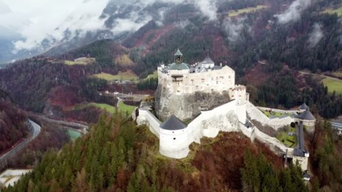 Video - Aerial drone view of Trausnitz Castle overlooking Landshut, a historic medieval fortress sitting on a hill above the Bavarian town, surrounded by forests and mountain landscapes