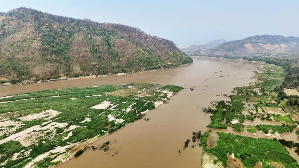 Video - Aerial drone view of the turquoise waters of Lago di Braies surrounded by dense alpine forest and dramatic limestone mountains in the Dolomites, Italy