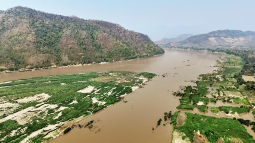 Video - Aerial drone view of the turquoise waters of Lago di Braies surrounded by dense alpine forest and dramatic limestone mountains in the Dolomites, Italy