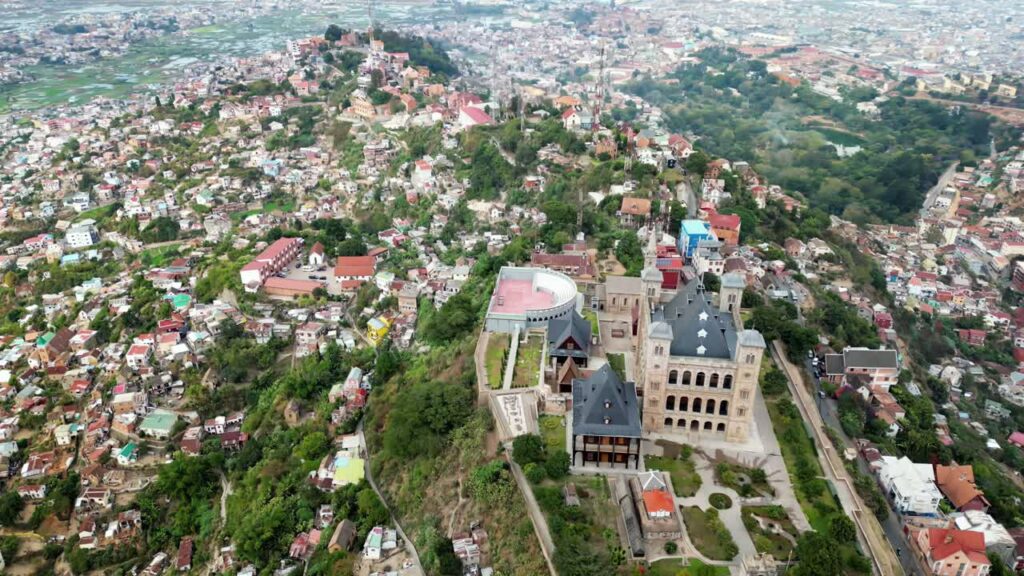 Video - Aerial drone view of Rova of Antananarivo royal palace complex, perched above the city and surrounded by tightly packed houses on the hillsides of Madagascar's capital