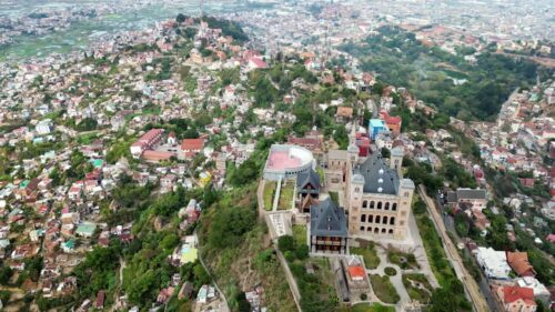 Video - Aerial drone view of Rova of Antananarivo royal palace complex, perched above the city and surrounded by tightly packed houses on the hillsides of Madagascar's capital