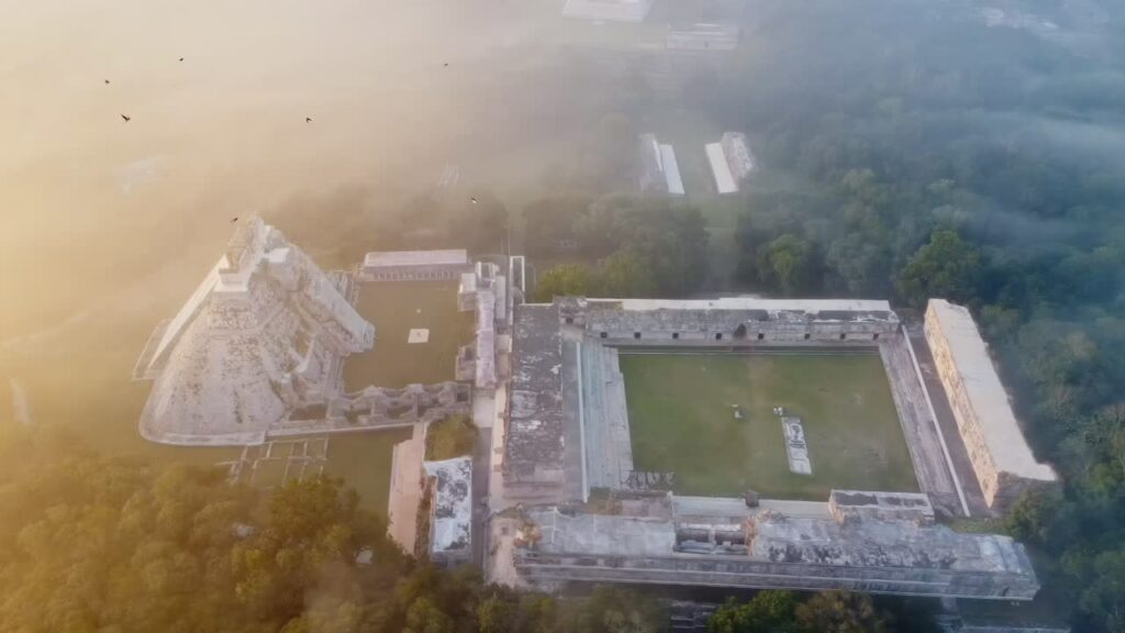 Video - Aerial drone view of Palenque Mayan ruins featuring ancient pyramids and temples surrounded by tropical jungle in southern Mexico
