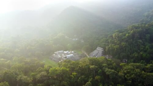 Video - Aerial drone view of Palenque Mayan ruins featuring ancient pyramids and temples surrounded by tropical jungle in southern Mexico