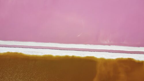 Video - Aerial drone view showing colorful salt evaporation ponds with pink and orange mineral water at Las Coloradas, Yucatan Peninsula, Mexico