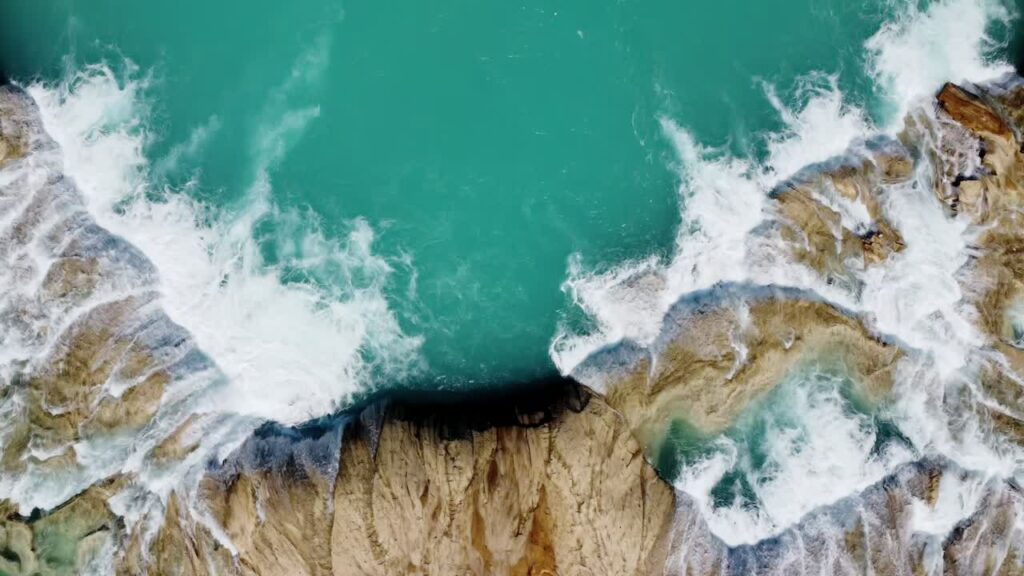 Video - Aerial drone view of a bright turquoise river flowing through dense tropical rainforest with lush green vegetation and natural jungle landscape in Mexic