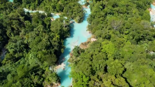 Video - Aerial drone view of Agua Azul's layered waterfalls and natural turquoise pools formed by mineral deposits in the Chiapas jungle