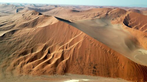 Video - Aerial drone view of endless sand dunes stretching across the Namib Desert creating dramatic patterns and textures