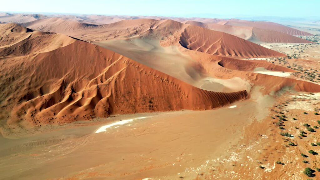 Video - Aerial drone view of endless sand dunes stretching across the Namib Desert creating dramatic patterns and textures