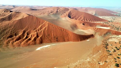 Video - Aerial drone view of endless sand dunes stretching across the Namib Desert creating dramatic patterns and textures