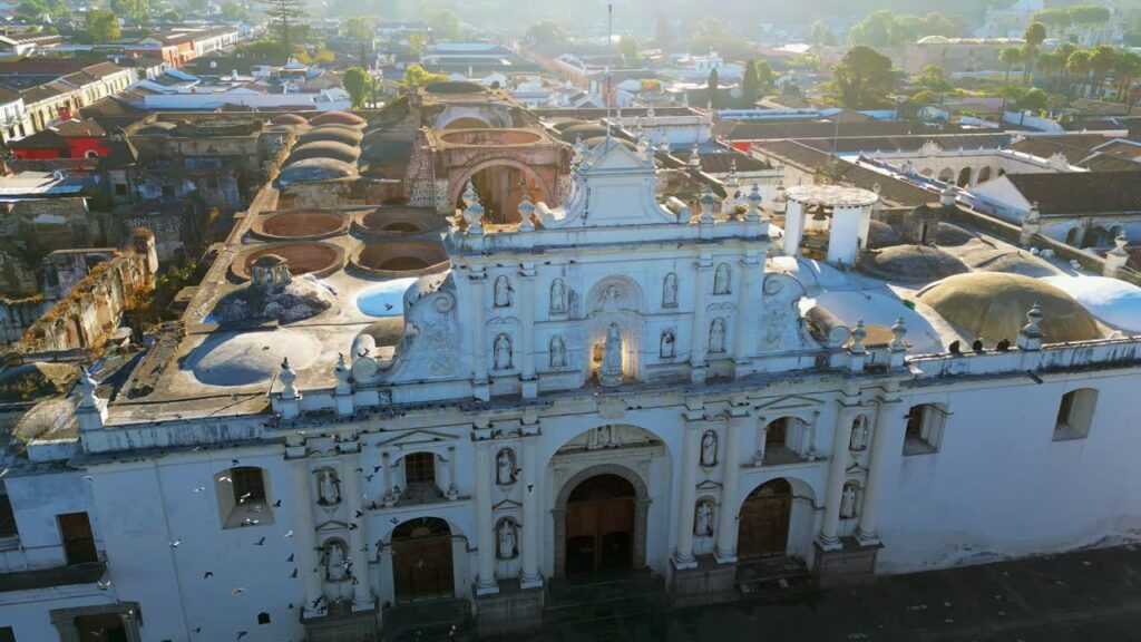 Video - Aerial drone view of the historic Antigua Guatemala Cathedral and colonial architecture in the early morning light
