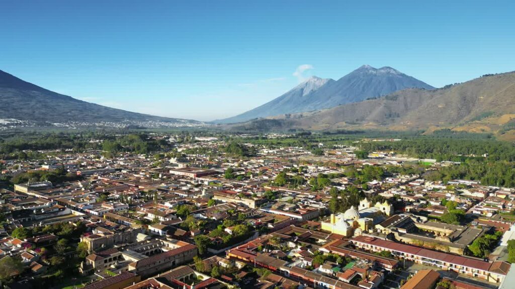 Video - Aerial drone view of Antigua Guatemala city with Volcan de Agua rising dramatically in the background