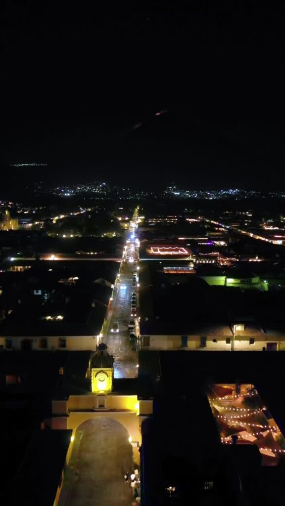 Video - Aerial drone view of the iconic Santa Catalina Arch and illuminated colonial street in Antigua Guatemala at night