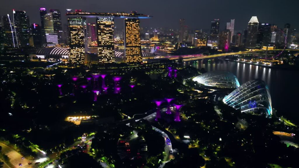 Video - Aerial drone view of Singapore's Marina Bay skyline featuring Marina Bay Sands, Gardens by the Bay Supertrees, and the illuminated city skyline