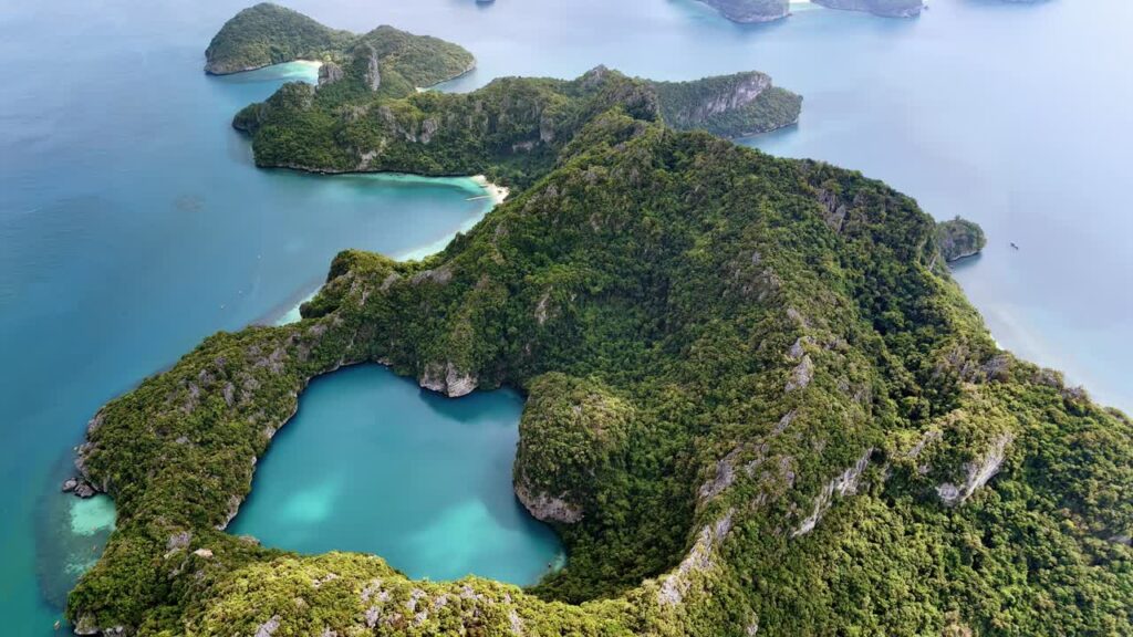 Video - Aerial drone view of a tropical island with white sand beaches and turquoise water bays in southern Thailand