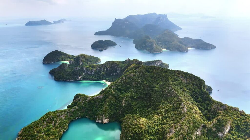 Video - Aerial drone view of a tropical island with white sand beaches and turquoise water bays in southern Thailand