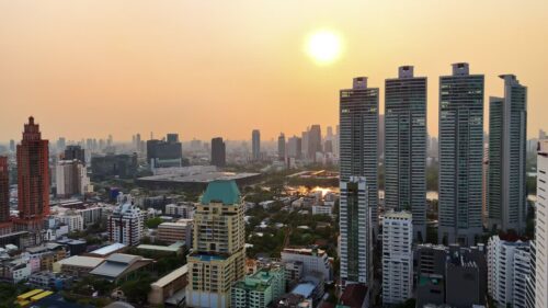 Video - Aerial drone view of Bangkok skyline at sunset with modern high rise buildings and golden evening light