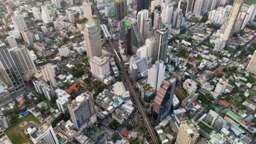 Video - Aerial drone view of Bangkok's business district with skyscrapers and the elevated BTS Skytrain railway running through the city Bangkok, Thailand - June, 6, 2025: