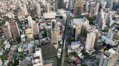 Video - Aerial drone view of Bangkok's business district with skyscrapers and the elevated BTS Skytrain railway running through the city Bangkok, Thailand - June, 6, 2025: