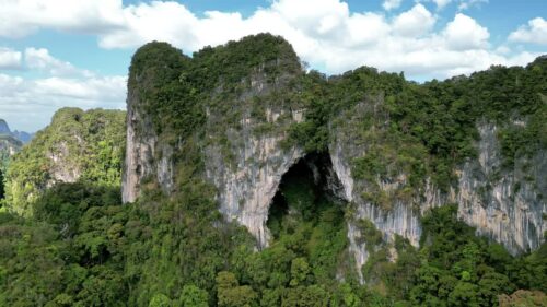 Video - Aerial drone view of lush tropical jungle covering steep limestone karst mountains in southern Thailand