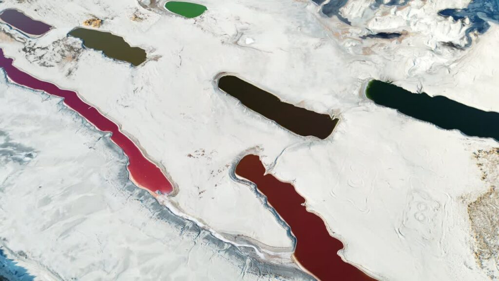 Video - Aerial drone view of colorful salt ponds and mineral pools in a dry desert landscape in Utah, United States