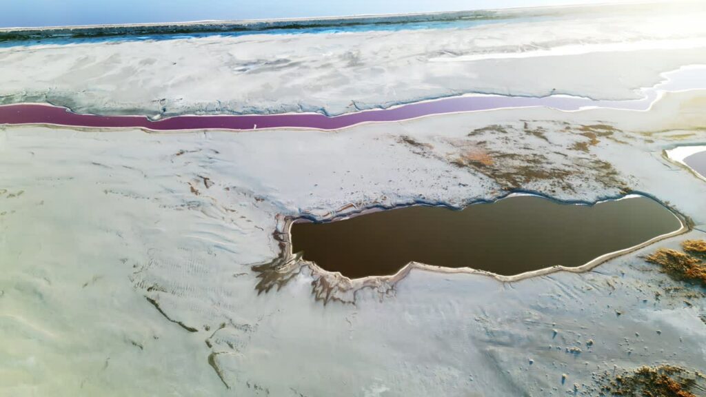 Video - Aerial drone view of colorful salt ponds and mineral pools in a dry desert landscape in Utah, United States