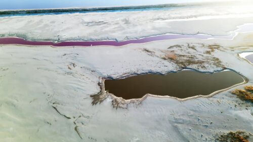 Video - Aerial drone view of colorful salt ponds and mineral pools in a dry desert landscape in Utah, United States