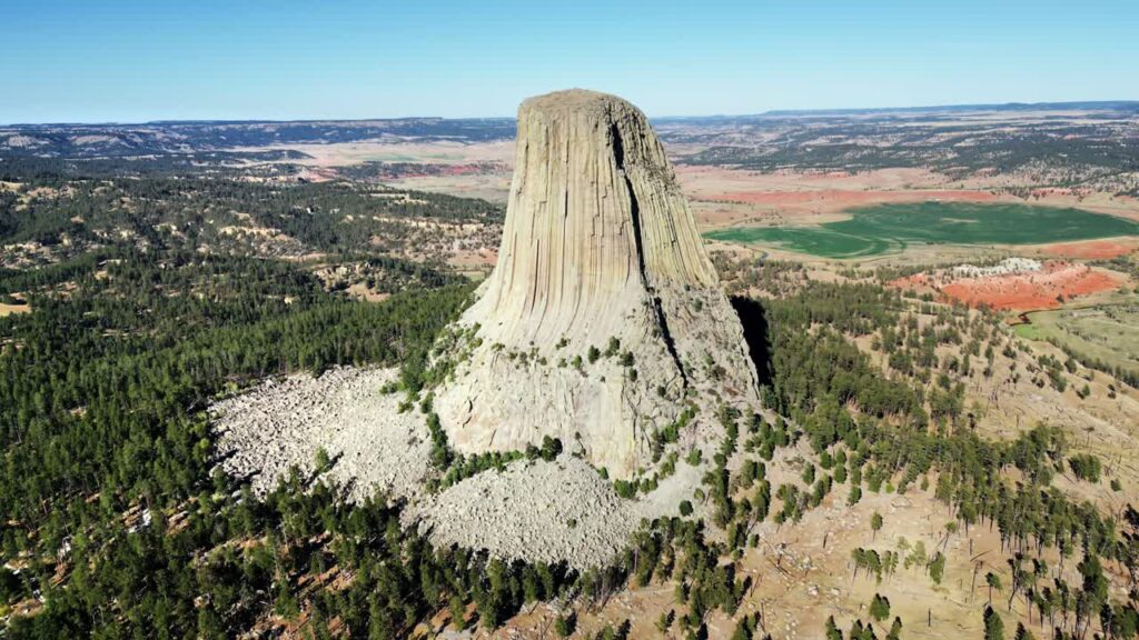 Video - Aerial drone view of Devils Tower National Monument rising dramatically above the surrounding landscape in Wyoming, US