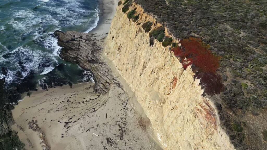 Video - Aerial drone view of dramatic coastal cliffs and waves along the rugged California shoreline