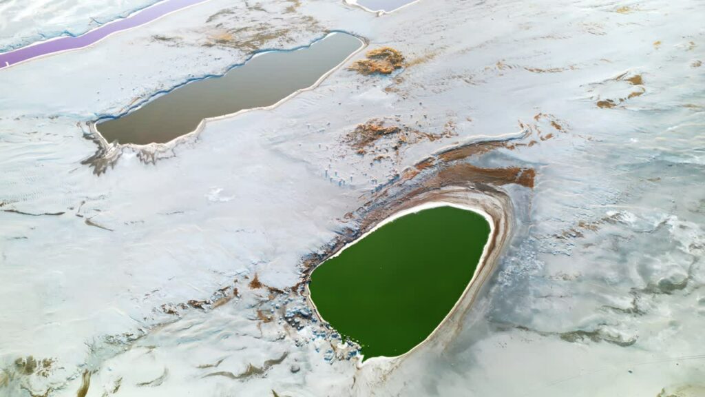 Video - Aerial drone view of colorful salt ponds and mineral pools in a dry desert landscape in Utah, United States