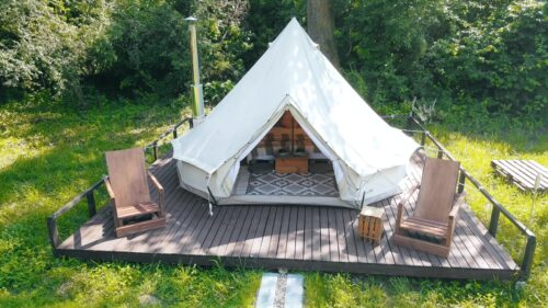 Video - Aerial drone view of entering a glamping tent in the middle of nature